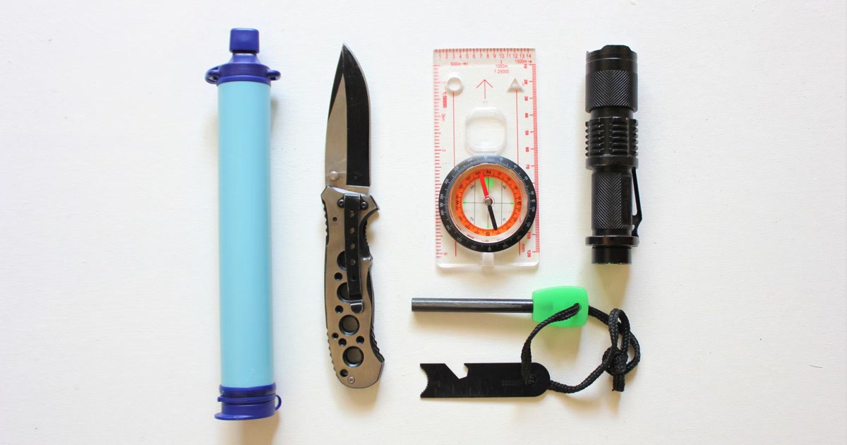 Get-home bag contents laid out: water, flashlight, power bank, first aid and map